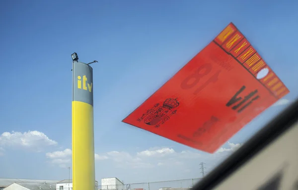 Distintivo de inspección técnica de vehículos en un parabrisas